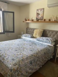 ein Schlafzimmer mit einem großen Bett mit Kissen darauf in der Unterkunft Marina Dor II - Cala Egos- Sunny ground floor apartment with large garden in Portopetro