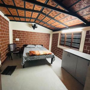 1 dormitorio con cama y pared de ladrillo en Dharani Home Stay, en Badami