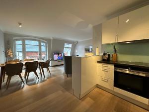 a kitchen and dining room with a table and a dining room at Hygge Nest im Haus Mateika in Westerland (Sylt)