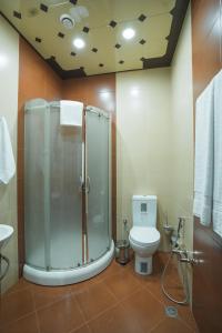 uma casa de banho com um chuveiro e um WC. em Ogguesto Hotel em Baku