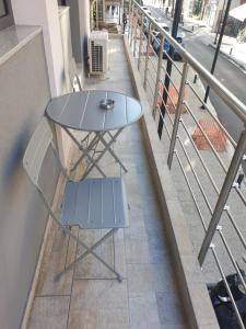 a table and a chair on a balcony at Olive Deluxe Apartment in Karditsa