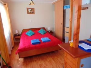sypialnia z czerwonym łóżkiem i niebieskimi poduszkami w obiekcie DEPARTAMENTOS CLIMENT w mieście Osorno