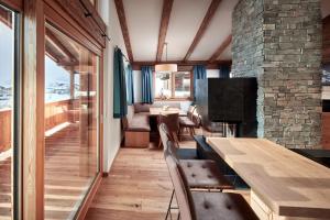 Pokój ze stołem i krzesłami oraz kamienną ścianą w obiekcie Alpin Residenzen Buchensteinwand St. Ulrich by Alpina-Holiday w mieście St. Ulrich am Pillersee