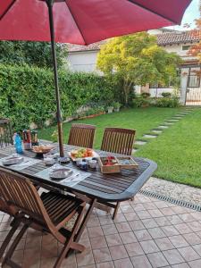 una mesa de picnic con una sombrilla en el patio en Il Colibrì Bed&Breakfast en Leno