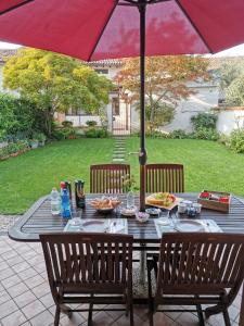 a table with a red umbrella on a patio at Il Colibrì Bed&Breakfast in Leno