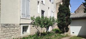 an old stone building with a tree in front of it at Appartement cosy à 2 pas des rues piétonnes in Chalon-sur-Saône