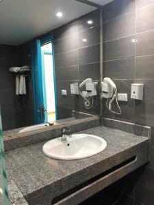 Mirage Bay Resort & Aqua Park في الغردقة: حمام مع حوض ومرآة