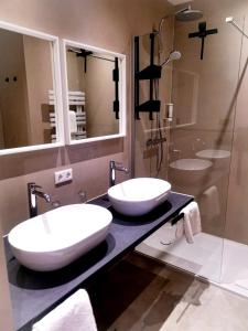 two sinks on a counter in a bathroom with a shower at Hotel Novalis Dresden in Dresden