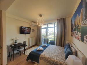 een slaapkamer met een bed, een tafel en een bureau bij Belgrade Waterfront Lux Apartment in Belgrado