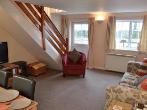 a living room with a couch and a chair at Glen Cottage in Yaxham