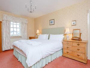 a bedroom with a large white bed and a window at The Old School House in Oldshore