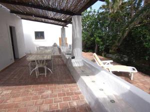 eine Terrasse mit einem Tisch und Stühlen auf einem Backsteinboden in der Unterkunft Ca Balena a mare in Stromboli