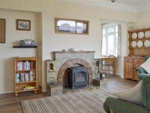 a living room with a stone fireplace in a living room at Longstone in Poundstock