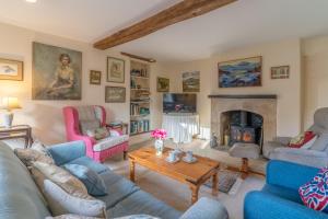 a living room with couches and a fireplace at Woodmancote Manor Cottage in Cirencester