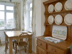 a dining room with a table and plates on the wall at Longstone in Poundstock