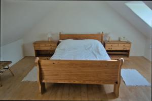 a bedroom with a wooden bed and two dressers at Sunset in Goodwick