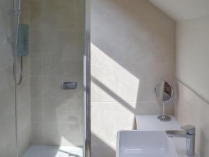a bathroom with a shower with a toilet and a mirror at The Piglet in Sidbury
