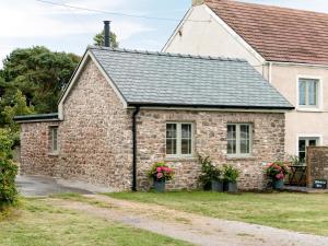 uma casa de pedra com um telhado preto em Blakeskerra Barn em Kenfig