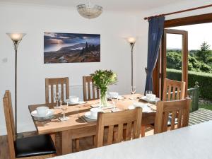 comedor con mesa de madera y sillas en Auldfield en Lhanbryd