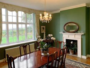 a dining room with a table and a fireplace at Castle Hill House in Sidbury