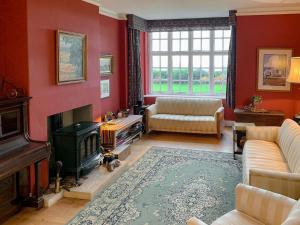 a living room with red walls and a fireplace at Castle Hill House in Sidbury