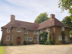 a large red brick house with a brown roof at Castle Hill House in Sidbury