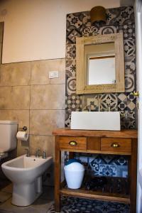 een badkamer met een wastafel, een toilet en een spiegel bij Cabañas La Sorpresa in Tilcara