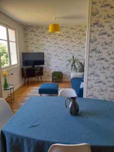 a living room with a blue table and chairs at La maison de Denise et Henri in Le Vigean