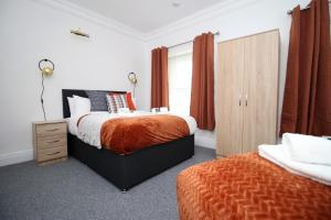 a bedroom with two beds and a wooden cabinet at Central House by MGroupSA in Newport