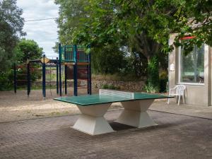 - une table de ping-pong devant une aire de jeux dans l'établissement Auberge de Jeunesse HI Nîmes, à Nîmes