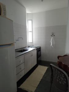 uma pequena cozinha com um lavatório e um frigorífico em Jardim Tropical em Lauro de Freitas
