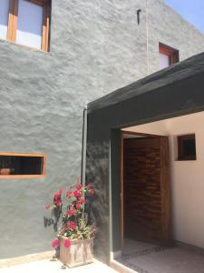 a building with a door and flowers in a pot at Cabañas La Sorpresa in Tilcara