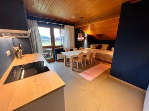 een keuken en een woonkamer met een bed en een tafel bij Apartmenthaus Rapplhof in Haus im Ennstal