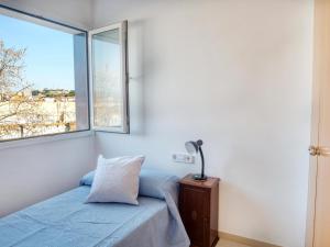 Schlafzimmer mit einem Bett und einem Fenster in der Unterkunft Piso les Pites in Palamós