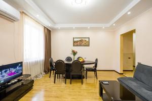 - un salon avec une table, des chaises et un canapé dans l'établissement Rustaveli Three Bedroom Apartment with Amazing views, à Tbilissi