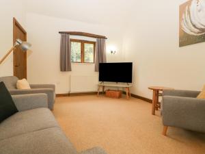 uma sala de estar com um sofá e uma televisão em Cinder Cottage em Worcester