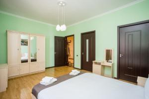 a bedroom with a large white bed and green walls at Rustaveli Three Bedroom Apartment with Amazing views in Tbilisi City