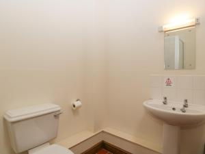 a white bathroom with a toilet and a sink at Cinder Cottage in Worcester +15 photos
