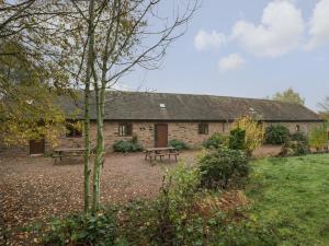 a stone building with two benches in front of it at Cinder Cottage in Worcester