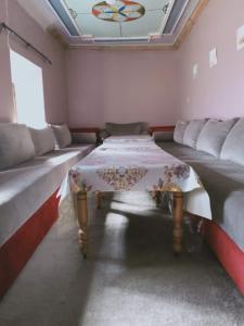 a room with two beds and a table in it at Kasbah Ait Bouguemez in Agouti