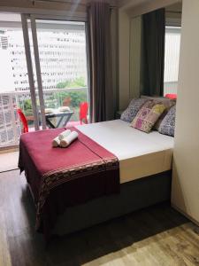 1 dormitorio con cama y ventana grande en Studio charmoso com varanda, en São Paulo