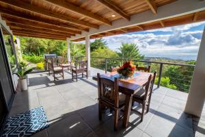 een patio met een tafel en stoelen op een balkon bij Flower’s Paradise Monteverde in Monteverde Costa Rica
