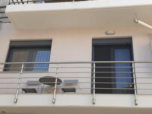 a balcony with two chairs and two windows at Olive Deluxe Room in Karditsa