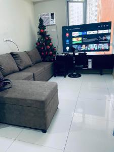 a living room with a couch and a christmas tree at U607 Sunshine100 Netflix 65Inches Android TV 40MBPS Wifi Karaoke in Manila