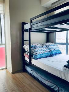 a bedroom with a bunk bed with pillows on it at U607 Sunshine100 Netflix 65Inches Android TV 40MBPS Wifi Karaoke in Manila