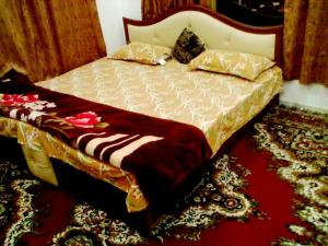 a bed in a room with a red carpet at Hotel Fabulous Kashmir in Srinagar