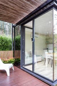 a conservatory with a sliding glass door on a deck at Villa no Jardim dos Aromas in Gião