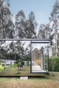 a glass house with a view of a bedroom at Villa no Jardim dos Aromas in Gião