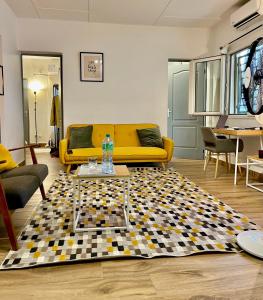 - un salon avec un canapé jaune et un tapis en damier dans l'établissement Dakar cosy maison avec terrasse by immo kit bnb, à Dakar