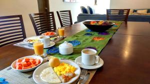 a table with plates of breakfast food and cups of coffee at Hotel Casa Nico in Barranquilla